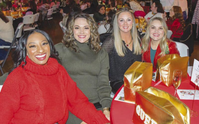 EVENING OUTING – From left, Brenae Moore, Lori Jones, Courtney Spruiell and Ashlea Kidd smiled at their reserved Fa La La table by the vendor stands in Levelland, Dec. 12. (Staff photo by Evin Thomas)