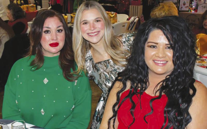 EARLY ARRIVAL – Stephanie Luebano, Natalie Page and Yadi Navarrete smiled at a decorated table reserved for their group at the Levelland Fa La La event, Dec. 12. (Staff photo by Evin Thomas)