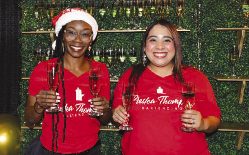 COMPLEMENTARY DRINKS – Hollee and Anna smiled with the champagne glasses they served to guests at Levelland’s Fa La La event Dec. 12. (Staff photo by Evin Thomas)