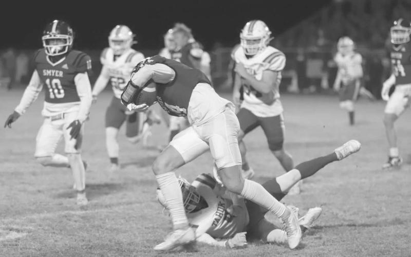 BALANCE BEAM - Smyer Bobcat Rylan Smith kept his balance while trying to be brought down by the Tahoka Bulldog defender last Friday night during the team’s last game of the season. (Photo courtesy of Joe-Andrew Garcia)