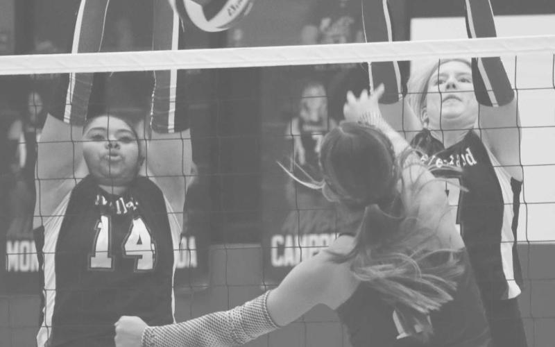 DETERMINED - Levelland Loboettes Trinity Wafers and Addisen Campbell jumped up for the block on the Littlefield player this past Tuesday at home. (Staff photo by Aalijah Soliz)