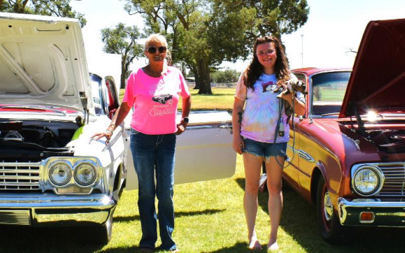 CITY PARK FUN – Pictured are Venus Holmes, Bailey Ayala, and Ayala’s puppy, Savy, with their cars. Holmes’s is a 1962 Chevy Impala and Ayala’s is a 1963 Ford Falcon. (Staff photo by Ada Niederhauser)