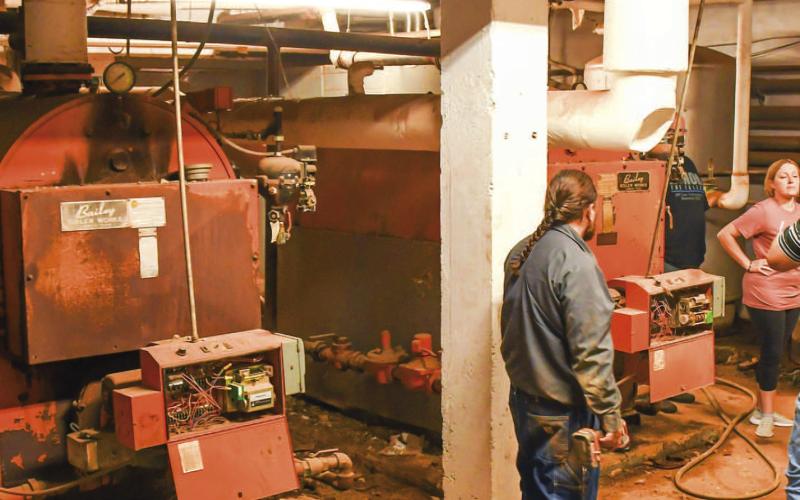 BOILER ROOM - Levelland ISD maintenance staff showed community members the Intermediate School basement boiler room during the Intermediate school closure tour Monday. Community members were advised to wear a mask while in the boiler room due to the presence of asbestos. Maintenance staff explained issues to community members such as electrical boxes degrading due to water damage. (Staff photo by Victoria Byrnes)
