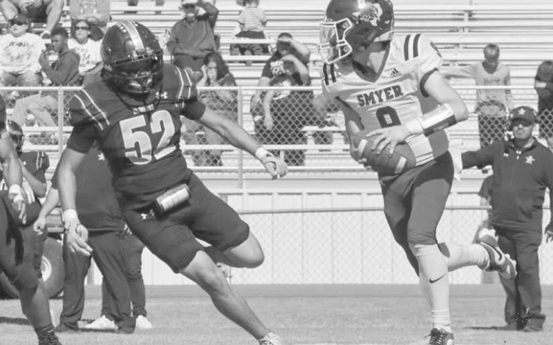 ON THE RUN - Smyer Bobcat Skyler Pond scanned downfield while under pressure from the Plains defensive player this past Thursday during the team’s district game. (Staff photo by Aalijah Soliz)