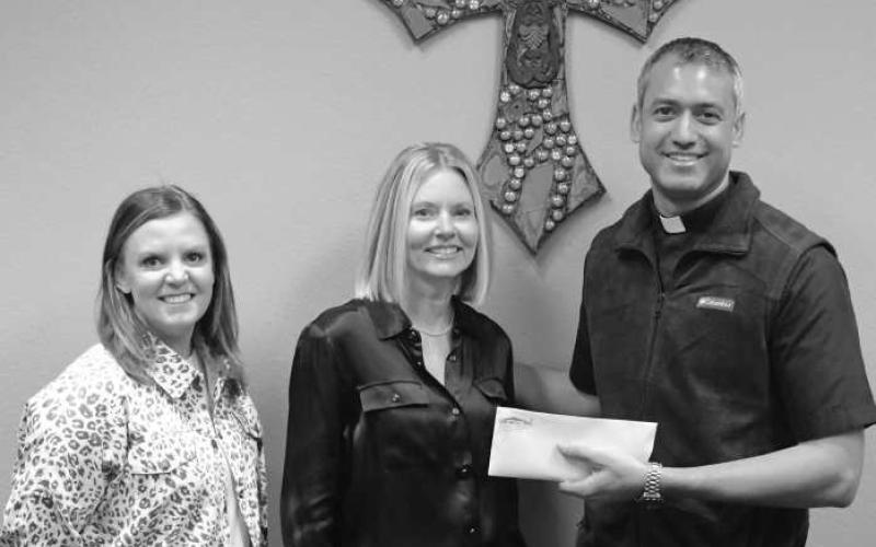 HELPING KIDS STAY FED - St. Michael’s Catholic Church in Levelland made a $1,000 donation to Bills BackpacksTuesday in the effort of keeping children fed. Pictured are Carrie Ellis and Amber Smith receiving the donation for the organization along side Father Jonathan Phillips. A quote that encouraged the church to make the donation was, “If you can’t feed 100 people, then just feed one.” (Staff Photo by Dom Puente)