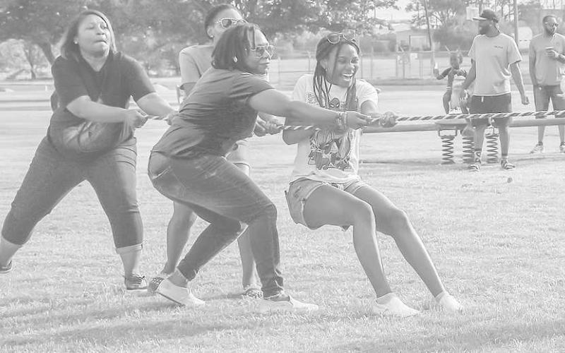 CHILDERS SISTERS- Sisters Joy, Patiance, Charity and Meekness Childers played a game of tug war last Friday during the 33rd Annual Juneteenth celebration. The evening festivities also included bingo, dominos, karaoke and a dance. (Staff Photo by Victoria Brynes)