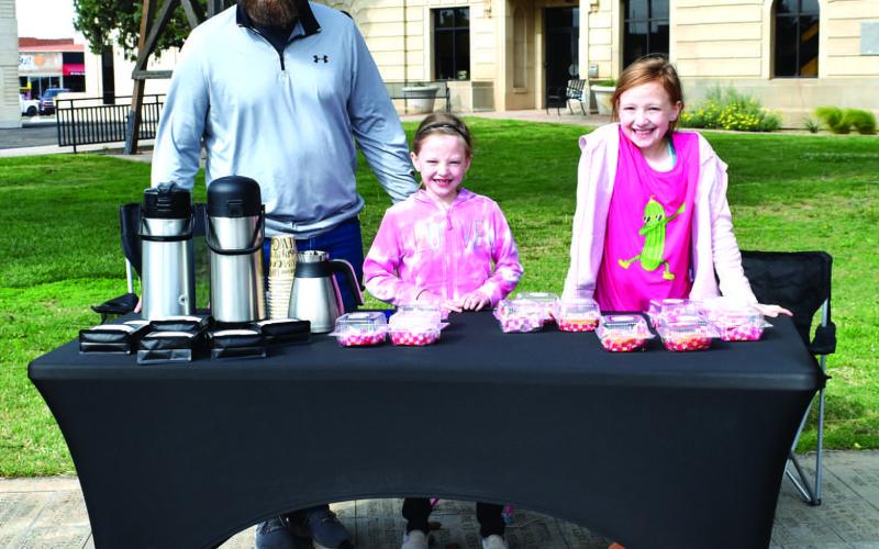 FAMILY FUN - Jacob Tucker and his daughters participated in the Lemonade Day event held by Levelland Main Street on Saturday down on the square. Pictured is Jacob Tucker selling his famous coffee, Lilly Tucker’s famous pickle bread and jam and Charley Tucker’s famous cookies. (Staff photo by Emily Campos)