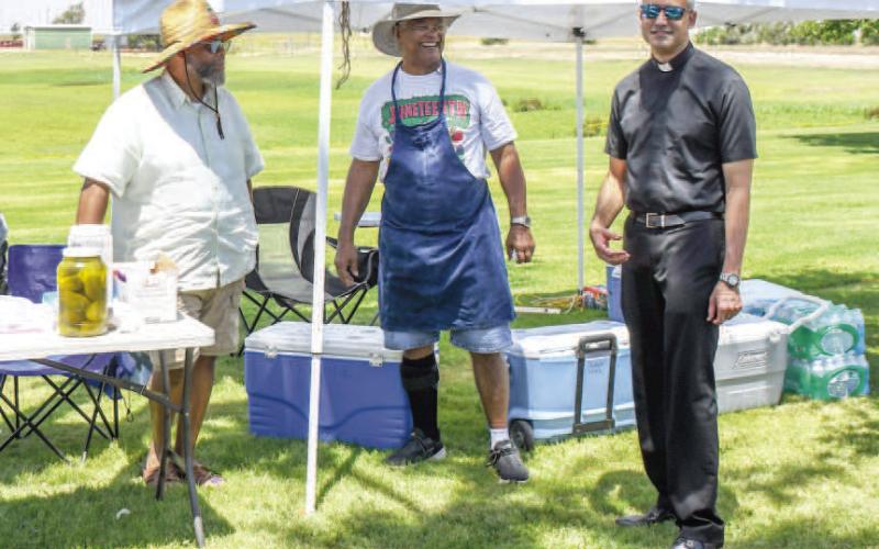 TIME TO EAT- Pictured from left to right are: Cederic Barnes, Butch Wade and Fr. Jonathan Phillips getting ready to eat BBQ at the annual Juneteenth Celebration. Community members were treated to brisket, chicken, hot dogs and dessert on Saturday at L.G. Griffin Park. (Staff photo by Essence Childers)