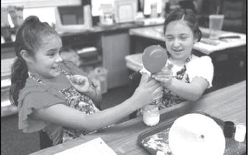 STATE OF MATTER - The fourth grade students in Mrs. Clara Sander’s Science classes at the Capitol Elementary school are learning about the states of matter. In photo Sofia Lopez and Keelyn Zamora are enjoying Hands-on-learning in the lab of what happens when matter are mixed together (photo submitted by Cristal Isaacks)