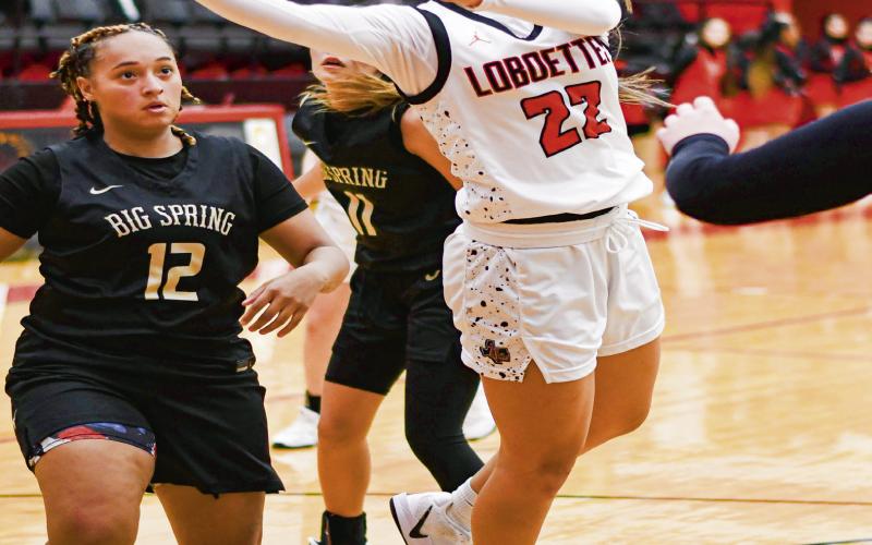 SPLIT THE DEFENSE - Levelland Loboette Jill Lopez splits three Big Spring defenders to put up a shot during their game this past Tuesday at Levelland High School. Lopez would score three points in the win. (Staff photo by Jentezen Smith)