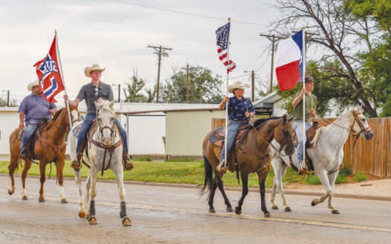 READY TO RIDE – Pictured are RD Motheral, Kye Powell, Bently Motheral, and Landry Farrar carrying the nations flag, state flag and Sundown flag at the beginning of the Oil Patch Days Parade on Saturday in Sundown. (Staff photo by Ada Niederhauser)