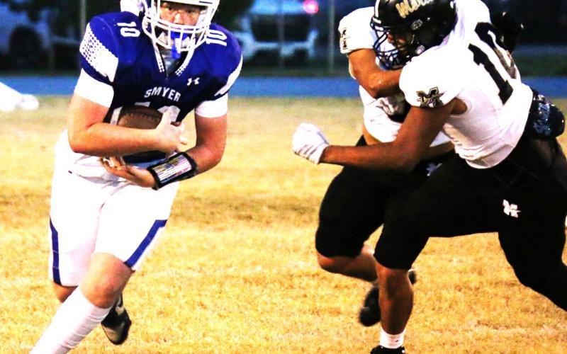 Smyer offense on the move as the Morton defense charges in for in for a tackle.