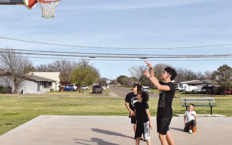 OUTDOOR FUN - As the Spring season brings warmer weather, community members are encouraged to visit their local parks that span the City of Levelland. With over 200 acres of parkland, the City of Levelland has 13 parks in total and 14 playgrounds. Pictured are: Daniel Martinez, 15, Gage Gonzales, 11, Cade Cristan, 5, and Jaden Gonzalez, 8, enjoying their Monday during Spring Break playing basketball at Bartlett Park. (Staff photo by Emily Campos)