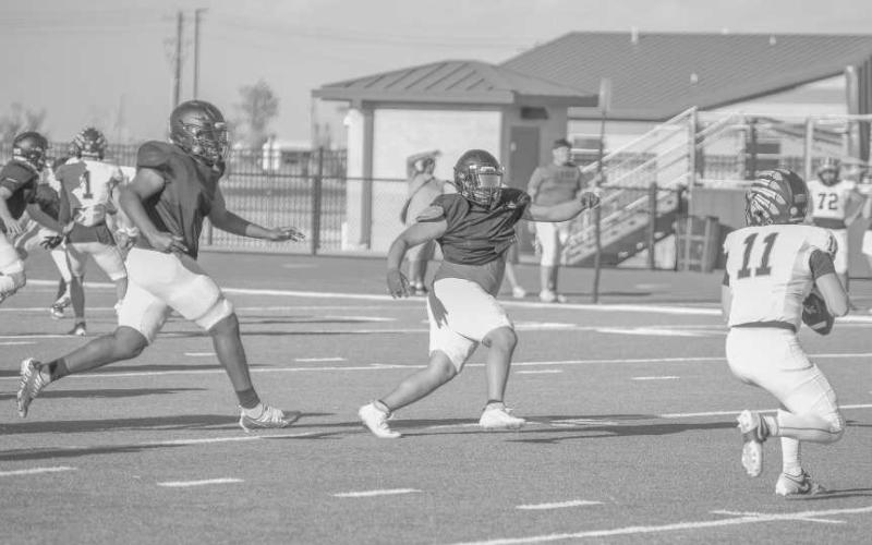 GET OVER HERE - Levelland Lobos Tanane Brackens and Zarian Valderas chased down the Seminole Indians quarterback this past Friday during the team’s first scrimmage of the year. (Staff photo by Dom Puente)