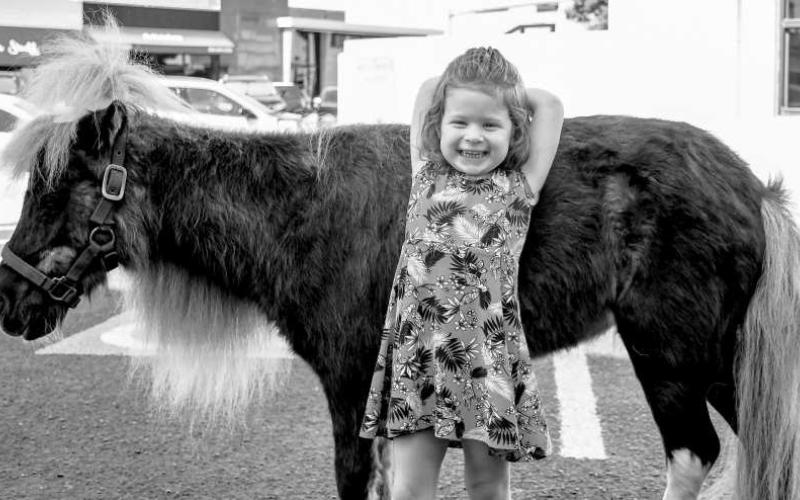GIDDY UP – Pictured is Kyndall Kaplan who was all smiles next to Buttercup, for the event Minis and Friends held by Hockley County Memorial Library on Wednesday. (Photo by Hannah Woodrum)
