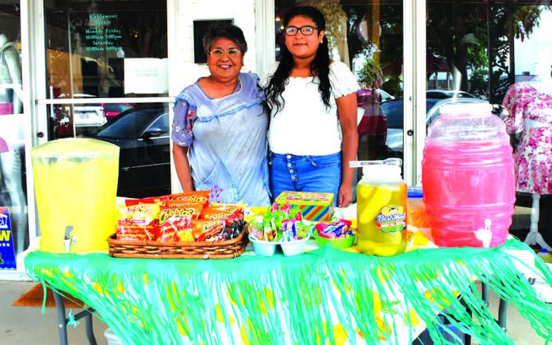 REFRESHING LEMONADE - The Levelland Main Street Program hosted a Lemonade Day event in downtown Levelland, Saturday. Pictured is Susie Ramirez and hr grandaughter Makenzy Mendoza. Lemonade Day was held in conjunction with Shop the Square and Community Planting Day. (Staff photo by Emily Campos)
