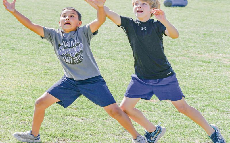 ONE-ON-ONE - Bobcat campers Trevor Solis (left) and Rhett Brazil (right) play one-on-one during their football session at Smyer High School. (Staff photo by Jentezen Smith)