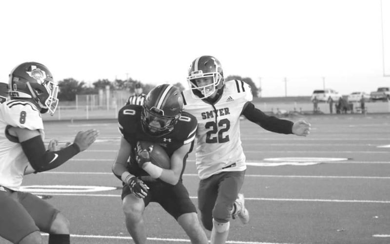 CHASEDOWN - Smyer Bobcat Peyton Casillas and Alex White made the tackle on the New Home player last Friday. (Staff photo by Aalijah Soliz)