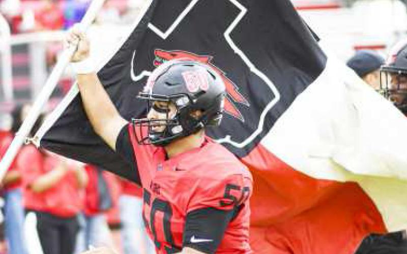 REPPIN’ THE LOBOS – Senior offensive and defensive lineman Deven Ponce proudly carries the Levelland Lobos flag as they take the field at Lobo Stadium for their football matchup against Pecos this past Friday night. The Lobos would go on to win 41-21. (Staff Photo by Jentezen Smith)