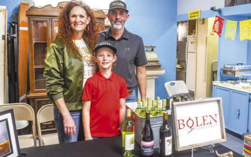 Tameisha, Gatlin and Rowdy Bolen smiled at the Bolen Vineyards table set up during Friday night’s Sip and Swirl event in Downtown Levelland. They served tacos to attendees along with their wine. (Staff photo by Evin Thomas)