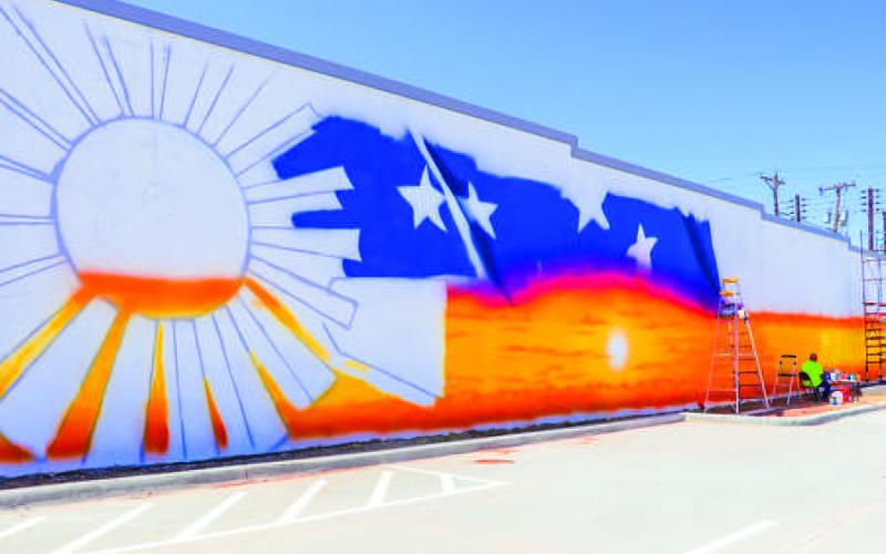 PURE SKILL - Painting for the new mural has begun at the new parking lot that was recently completed at the corner of Austin Street and Avenue H across from the Hockley County Annex. Alfonso Garcia of Tulia is tasked with completing the mural. Weather permitting, the artwork should be completed in four weeks. (Photo courtesy of Emily Campos)