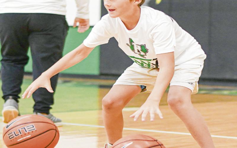 DRIBBLE DRILLS - Eagle camper Huxx Castleberry focuses to control two basketballs during dribble drills this past Tuesday at the Ropes High School gym. (Staff photo by Jen - tezen Smith)
