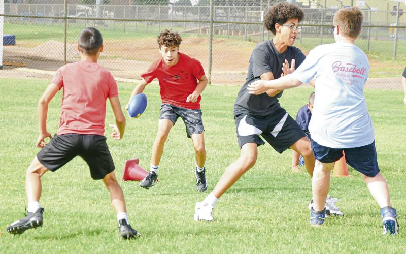 TACKLE PURSUIT DRILL - Antelope camper Noah Guillen rushes the football while Tabyus Castaneda blocks for him and Reed Crutcher and Kenston Lattimore look to make the two-touch tackle during a tackle pursuit drill at the Whiteface Sports Skills Camp this past Wednesday at Whiteface High School. (Staff photo by Jentezen Smith)