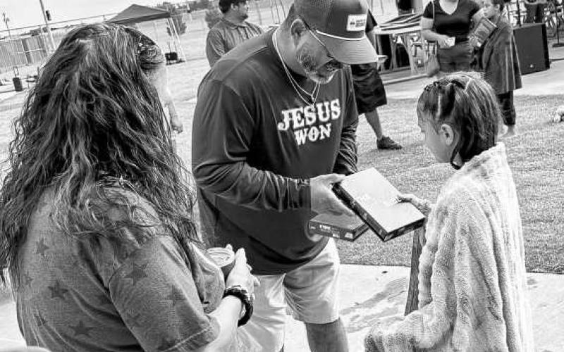 HAVE A BIBLE – Eric Ochoa from “Safe at Home” gives a Bible to a freshly baptized softball girl on June 29 at the OXY complex. (Staff photo by Jentezen Smith)