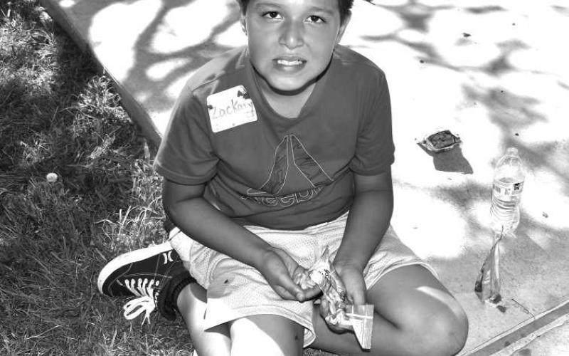 SNACK TIME - Oasis Vacation Bible School was held at the Kaufman Park on Wednesday. There were many activities for the kids to take part in. The event also included refreshments and snacks. Pictured is Zack Hernandez enjoying snack time. (Staff photo by Emily Campos)