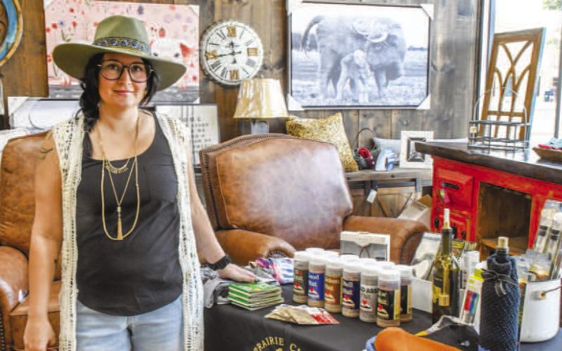 Keitha Lane stood with the Prairie Chick table inside Austin Street’s Our Stuff store, offering wine and food items to attendees of Friday night’s Sip and Swirl event. Prairie Chick was one of six wineries at the event. (Staff photo by Evin Thomas)