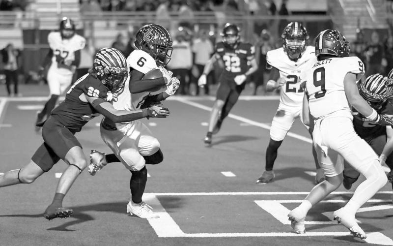 GOING FORARIDE - Lobo Eryk Jones took a Seminole defender for a ride during the team’s playoff game aginst the Indians in Denver City this past Thursday. (Staff photo by Aalijah Soliz)
