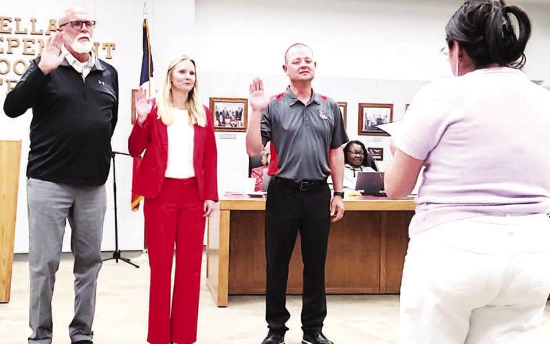 LISD SWEARING IN-- LISD administrative secretary Crystal Hill swore in the board members elected to serve at the recent meeting: Gary Bridges, Carrie Ellis and Matt Buxkemper. (Staff photo)