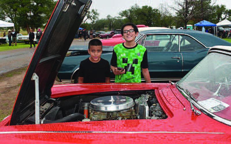 ANERICANMUSCLEENGINE-- Sergio Flores, 8, of Levelland and Aiden McAlister, 11, of San Angelo, were admiring the V8 American Muscle engin in the 1961 Corvette displayed at the Thunder on the Plains Classic Car Show Saturday. The Corvette belongs to Mark Mitchell of Lubbock, who has owned the classic since 1989 and fully restored it himself. (Staff Photo)
