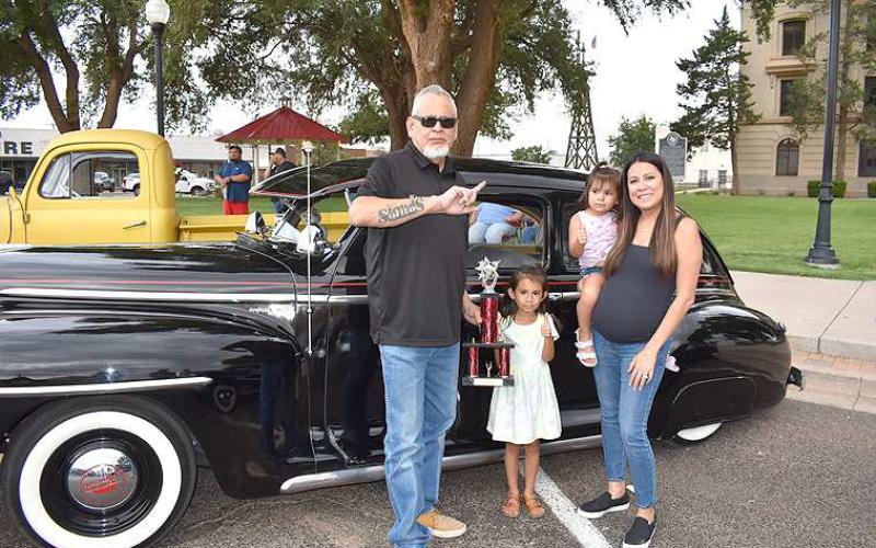 1947PLYMOUTHDELUXE– Rudy Rivera of Levelland, received a People’s Choice award from Sophia Chapa, 5, and her little sister, Stassi Chapa, 2, both daughters of Amanda Chapa, all of Levelland. Rivera has owned the classic for more than 15 years and restored it himself. He enjoyes showing the car in the Solitos Car Show in Chicago. (Staff Photo)