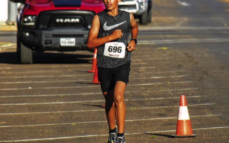 GOOD COMPETITION - Runners participating in the Run the Mosaics Bobby Birdsong Memorial race Saturday in downtown Levelland raced for their best times as a 10K, two mile and one mile race were held for participants who wanted to get their steps in. Runners finishing their race received cheers from other participants and spectators near the finish line. (Staff Photo by Dom Puente)