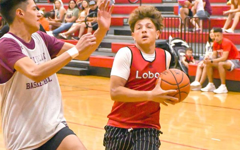 TWO POINTS -The Levelland Lobos hosted the Littlefield Wildcats and Canyon Eagles in two summer exhibition matches Thursday at the Levelland Middle School. Pictured is Lobo Kysen Niblett attempting a lay-up with a Wildcat defender cutting off his path at the basket. (Staff Photo by Aalijah Soliz)