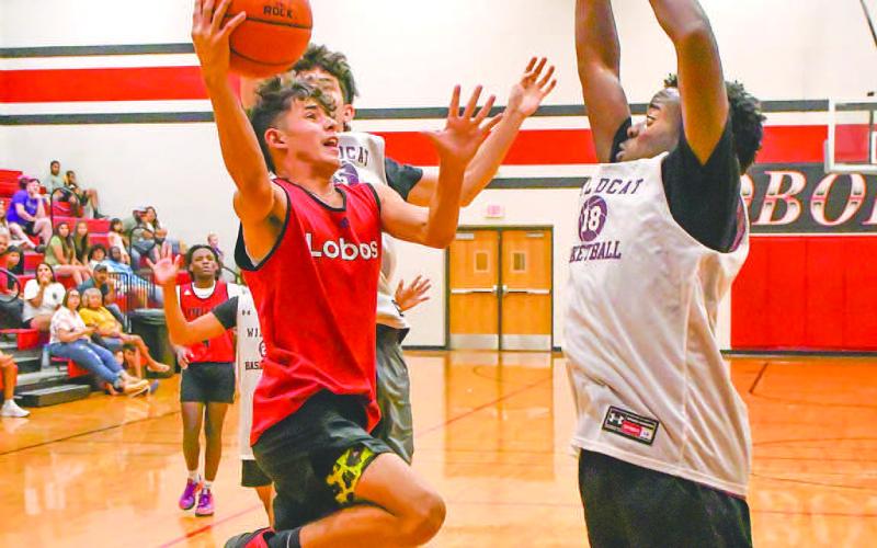 LAY UP - The Levelland Lobos hosted the Littlefield Wildcats and Canyon Eagles in two exhibition matches Thursday at the Levelland Middle School. Pictured is Lobo Malachi Gavina putting up a shot over two Littlefield defenders. (Staff Photo by Aalijah Soliz)