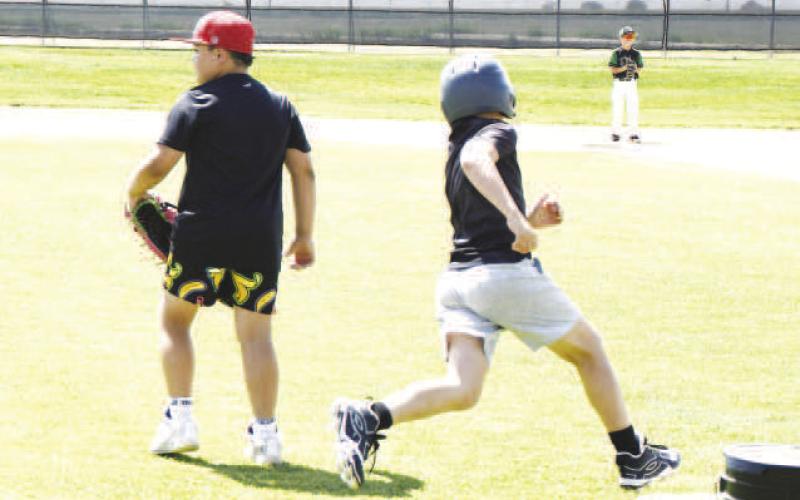 ROUNDING THE BASE- A camper hits a lead-off double in a scrimmage during the Ropes youth baseball camp and rounds around first base to head to second. (Staff photo by Trinity Boudreaux)