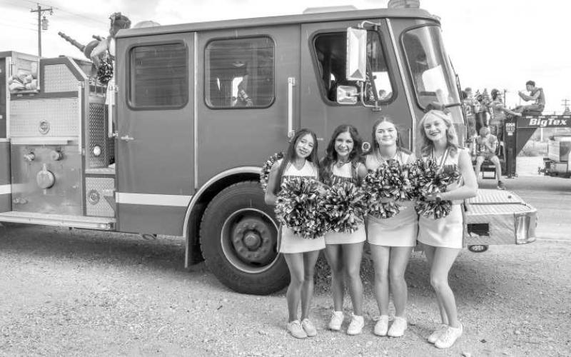 GO SUNDOWN! - Pictured are Sundown Cheerleaders Kaytlin Clausen, Emma Escamilla, Brooklyn Keesler and Sarah Posadas posing in front of a fire truck before walking in the Oil Patch Days Parade on Saturday. (Staff photo by Ada Niederhauser)