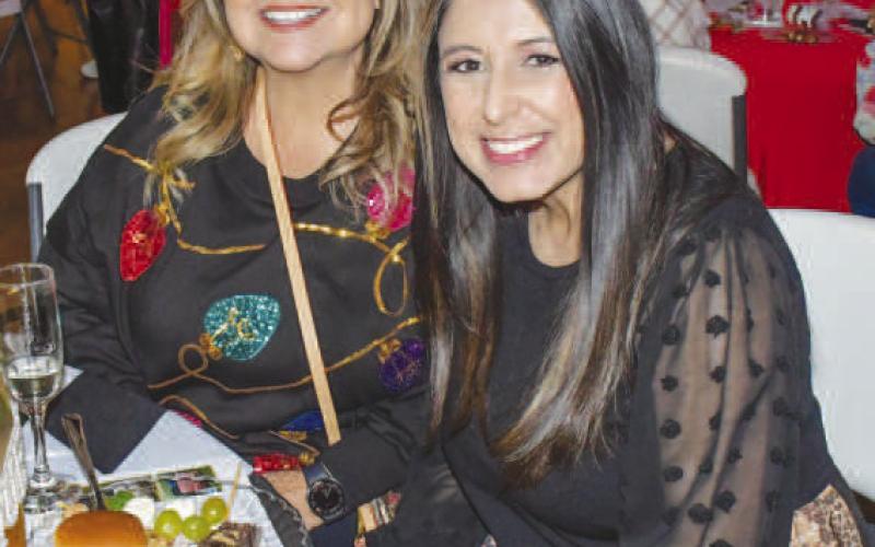 SNACKS – Chrissy Davila and Alexis Gavina smiled together with their plates of food during Levelland’s Fa La La event Dec. 12. (Staff photo by Evin Thomas)
