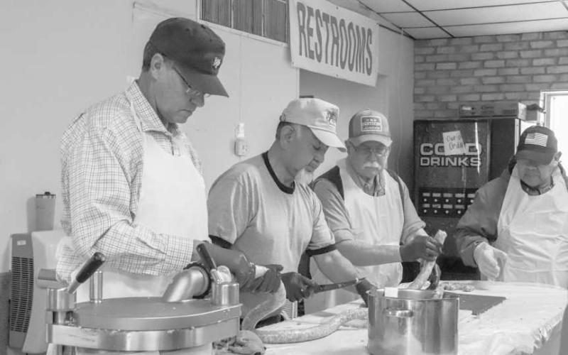 GROUP EFFORT - Pictured is David Albus, Henry Pompa and Dixon Moreland preparing the sausage for the 40th Annaul Sausage Lovers Festival which will be held Sunday, Feb. 16 at St. Michael Catholic Church. (Staff photo by Adriana Solis)