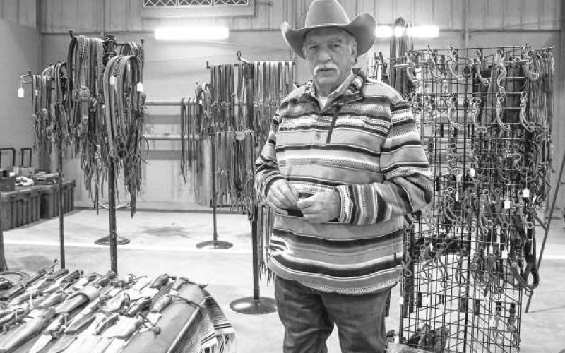 WIDE VARIETY – Larry Porter stood next to his display of knives and other equipment set up at the Clovis Horse Sale trade show on Nov. 23 in Levelland. (Staff photo by Evin Thomas).