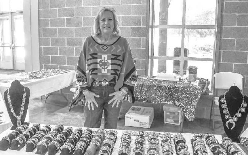 TURQUOISE ARRAY – Jan Narramore smiled behind her display of turquoise necklaces and bracelets that she sold at the Clovis Horse Sale in Levelland on Nov. 23. (Staff photo by Evin Thomas)