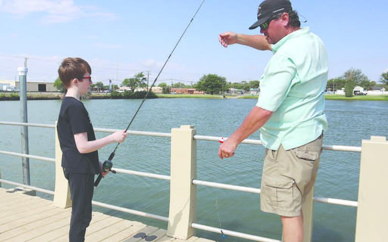 HOOK AND REEL- Wes Utley was teaching Blake Moore how not to get his line caught on anything at Lobo Lake July 6, 2023. (Staff Photo by Aalijah Soliz)