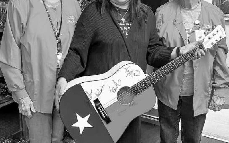 RAFFLE WINNER - Janie Mireles was recently announced as the Sugar Plum Gift Shop Raffle winner of a guitar signed by Kenny Maines. The proceeds from the raffle go toward scholarships or care givers. Additionally, other proceeds are for equipment for hospital needs. Pictured are Mireles with Kay McDaniel and Judy McMinn. (Submitted Photo)