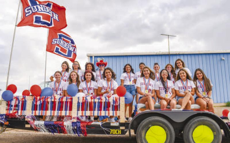 SOFTBALL FLOAT – The wind was perfect to catch the flags on the Sundown Softball team’s float for the Oil Patch Days Parade on Saturday. Players could be seen wearing gold medals from their win at state earlier this year. (Staff photo by Ada Niederhauser)