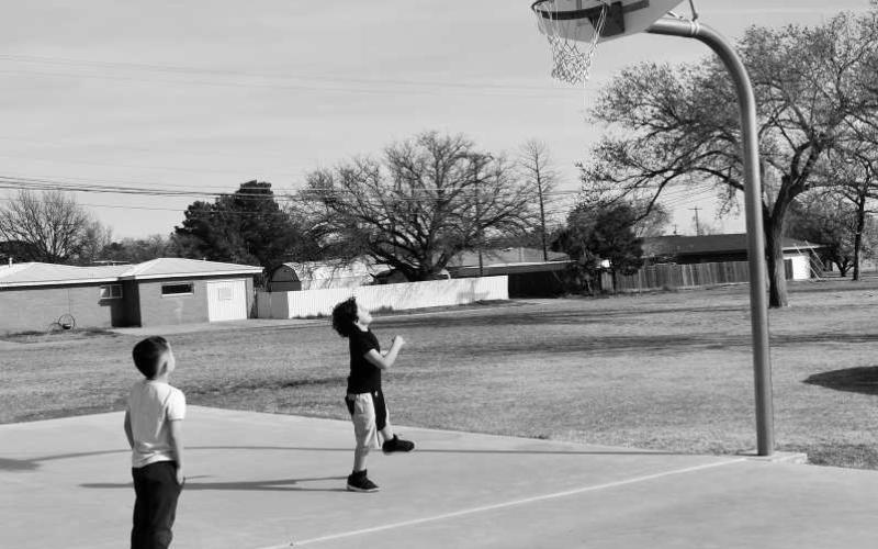 PLAYING BASKETBALL- At the Barlett Park on Tuesday there were two friends playing basketball and enjoying Spring Break. Pictured is Jaden Gonzalez 8, shooting the basketball and Cade Cristan 5, waiting for his turn to get the basketball. (Staff photo by Emily Campos)