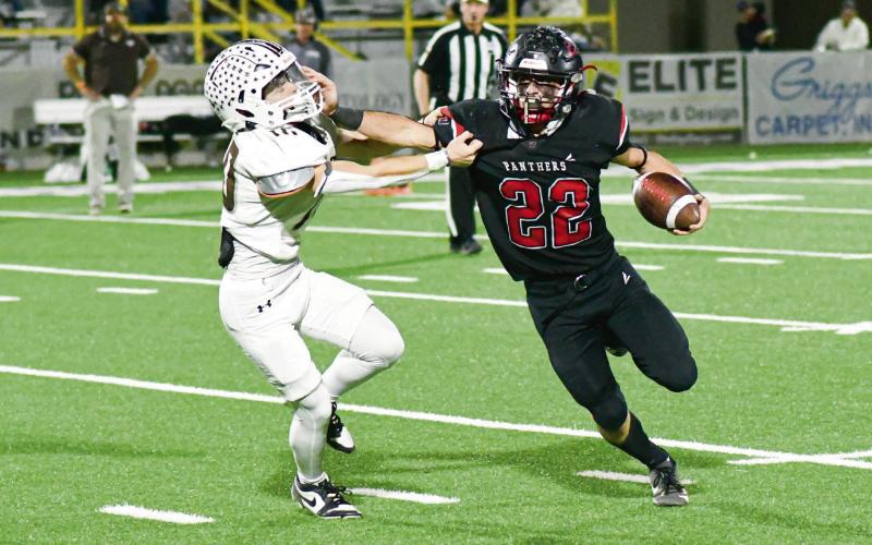 STIFF ARM BY JOHNSON - Whitharral senior running back Greg Johnson rushes the football and stiff arms a Sands defender during their playoff football game this past Friday night. Johnson would rush for 187 yards and three touchdowns in the loss. (Staff photo by Jentezen Smith)
