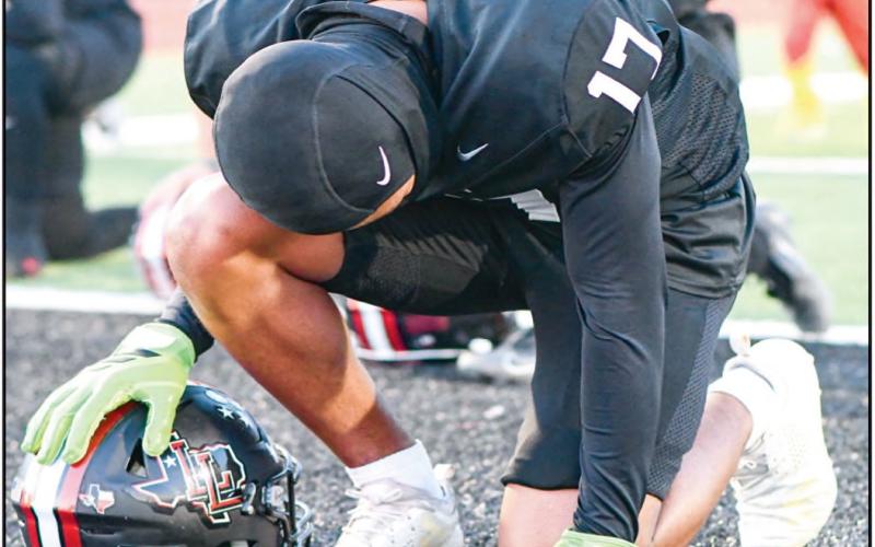 ENDZONE PRAYER - Levelland freshman Bentley Sepulbeda takes a knee in the end zone for a pregame prayer before their football game against Borger this past Friday night. (Staff photo by Jentezen Smith)