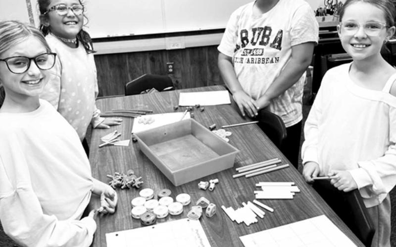 BLINDED BY SCIENCE-- Capitol students in Mrs. Clara Sanders' classes participated in a lab learning about the physical properties of matter. Mrs. Sanders challenged students to classify objects into groups by their characteristics and write down physical traits helping students connect science with writing. Pictured are Stella Coats, Emma Leach, Annalise Sanchez and Lilly Luna (Photo courtsey of Cristal Isaacks)